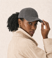 Woman wearing The Silk-Lined Hat in Charcoal with a cream trench coat