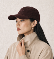 Woman wearing The Silk-Lined Hat in Oxblood with a cream trench coat