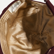 The Silk-Lined Hat in Oxblood, champagne-gold silk interior close-up